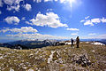 Two hikers leave Guri Kuq summit 2522 m alt in Rugova gorge. Far away on the left are Junik and Deçani mountains and on the right, are mountains of Montenegro.