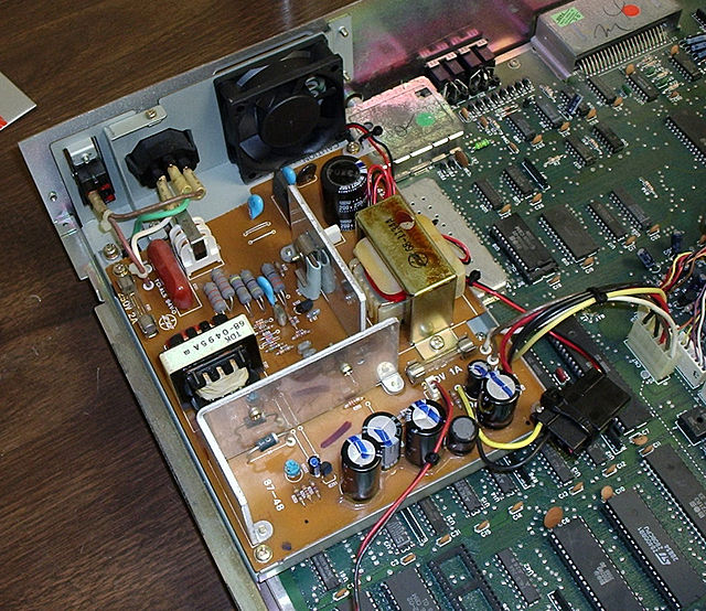 Commodore 128DCR computer's switch-mode power supply, with a user-installed 60 mm cooling fan. Vertical aluminium profiles are used as heatsinks.