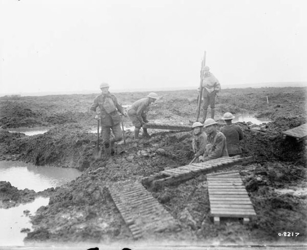 Canadian pioneers laying trench mats over mud to ease movement