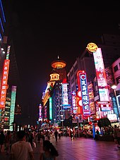 Вечерняя пешеходная улица Нанкина с видом на отель Radisson New World. Это популярный торговый центр Шанхая.
