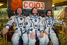 Soyuz TMA-14M mürettebatı uzay araçlarının önünde.jpg