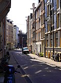 Street view of the Peperstraat in Amsterdam city with sun; free photo Amsterdam, 2020