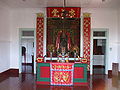 Second Floor Altar to Lord Guan. Other guardian Deities altars are to the left and right of the photo. An altar to the deceased is to the right of the photo behind the chain barricade.