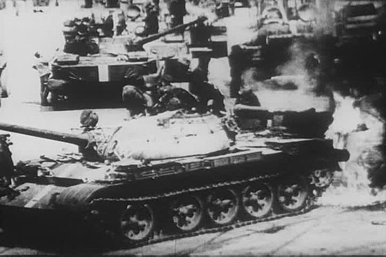 A Soviet T-55 tank catches fire while battling Czech protesters during the 1968 invasion of Czechoslovakia.