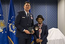 Командующий космическими силами ВВС вручает Глэдис Уэст награду в честь ее включения в Зал славы пионеров космической и ракетной техники ВВС за ее работу в области GPS, 6 декабря 2018 года.