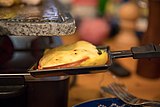 A slice of raclette cooked with an individual pan in an electric grill