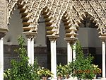 Polylobed arches in the Mudéjar-style Patio de las Doncellas at the Alcazar of Seville in Spain (14th century)