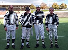 An American Football officiating team at Saffron Lane in 2001, the banked velodrome track and north stand can be seen in the background BAFRA crew Saffron Lane.jpg