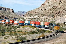 Train in Arizona, with 20-, 40- and-53 foot containers double stacked in well cars BNSF 5216 West Kingman Canyon AZ (293094839).jpg