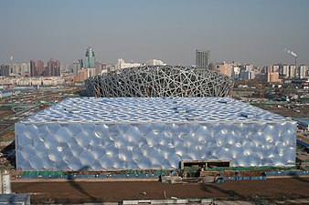 The National Aquatics Center under construction, with the Beijing National Stadium in the background
