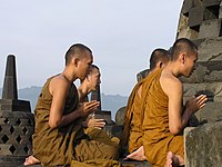 Peregrinos budistas meditando en la cima del templo.