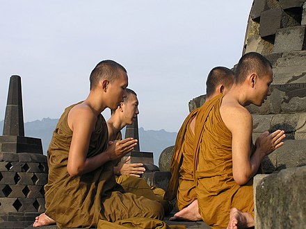 Buddhist pilgrims meditate on the top platform