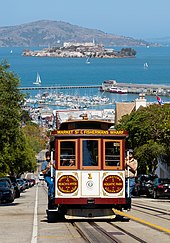 A cable car ascending Hyde St, with Alcatraz on the bay behind Cable Car No. 1 and Alcatraz Island.jpg