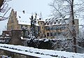 Schlossfassaden und Dächer der beiden Flügel mit Türmen, Eingangsbastion, Innenhof mit Brunnen, umgebende Mauer, Wassergraben