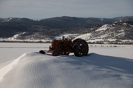 Disused tractor on a snow-covered field in Star Valley, Wyoming, USA.jpg