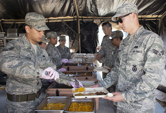 U.S. Air Force airmen serving Unitized Group Rations prepared in a single palletized expeditionary kitchen