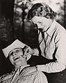 Female student shaves male student (University of Houston Frontier Fiesta, 1950s).jpg