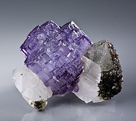 Freestanding purple fluorite cluster between two quartzes