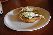 Fried turnovers filled with black beans and other ingredients served at Frontera Corozal. Fried empanadas with cheese, beans and lettuce on top.jpg