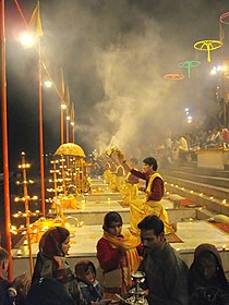 Evening Ganga Aarti at the adjacent Dashashwamedh Ghat, Varanasi in 2008, with people watching from the steps above. Ganga Aarti at Varanasi ghats.jpg