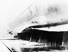 Photograph of Belfast's damaged hull, taken while the ship was drydocked for repairs. Hms belfast mine damage.jpg