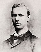 A young man in a dark jacket with a dark bow tie