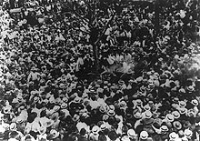 Photographie en noir et blanc d'une foule agglutinée autour d'un arbre et de Jesse Washington.