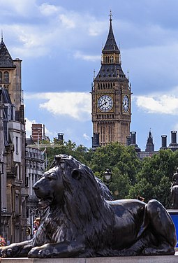 One of the statues of lions (1867) by Edwin Landseer and Carlo Marochetti at the foot of Nelson's Column, with the Elizabeth Tower in the background. London - Trafalgar Square - Big Ben - 140811 114241.jpg