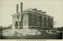 Üç katlı bir tuğla binanın siyah beyaz fotoğrafı