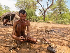 San Mann fügt gefertigte Spitze aus Giraffenknochen an den Pfeilschaft aus hartem Gras.