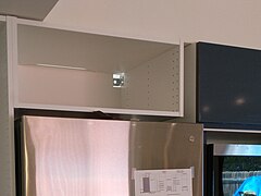 There was a 3" (8 cm) gap between the cabinet above the fridge and the high cabinet to the right.