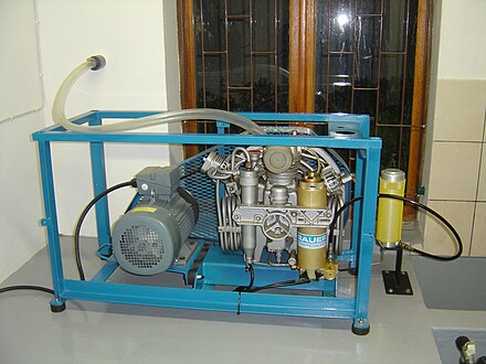 Small stationary Bauer HP breathing air compressor installation showing water separator (centre), and two high pressure product filter housings (gold anodised) to produce oxygen compatible breathing air for diving gas mixtures.