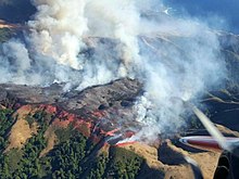 The 2016 Soberanes fire tops a ridge covered in fire retardant adjacent to the Pacific Ocean