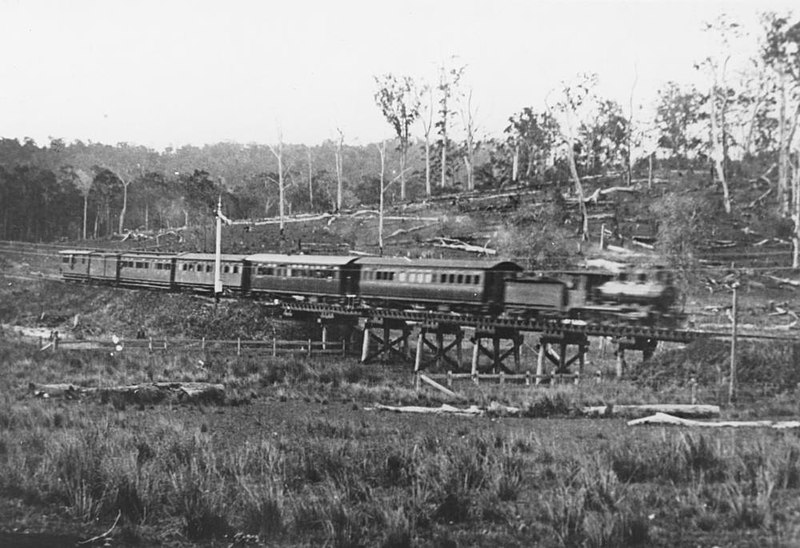 File:StateLibQld 2 296239 Passenger train from Cooroy crossing the bridge near the Butter Factory, Eumundi, 1915.jpg