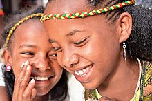 A girl whispers to another girl. Two Girls, Tigray (14991776680).jpg