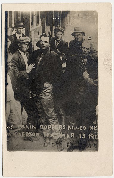 Photograph shows the bodies of Ben Kilpatrick and Ole Hobek being held up by others after being killed near Sanderson Texas, March 13, 1912