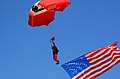 US Navy 050917-N-2197S-004 A member of the British Army Parachute Demonstration Team slowly descends to the ground with the American flag.jpg