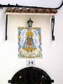 Vista de plafón cerámico con la imagen de la Virgen de los Desamparados en la fachada de una casa de Ademuz (Valencia), año 2003 (s/f).