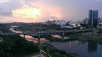 The Skyline of Pune as seen over the Mutha River. Aga Khan Bridge in Pune.jpg