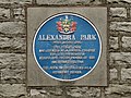 A blue plaque seen on the side of the North Lodge in Alexandra Park