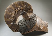 Mască igboeană de lemn, pictată și pozată din profil. Ea este decorată cu motive geometrice ca spirale, linii paralele și discuri. Masca are doi ochi mici cu spâncenele arcuite, nasul ascuțit și gura deschisă. Acesta datează din secolul al XIX-lea și se află la Brooklyn Museum din New York, Statele Unite ale Americii.