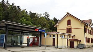 Three-story building with gabled roof and adjoining shelter