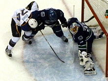Schneider in February 2011 making a glove save with St. Louis Blues forward T. J. Oshie at the crease. Cory Schneider save 02-2011.jpg