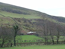 A Talyllyn Railway train climbing eastwards along the Fathew Valley between Brynglas and Dolgoch Edward Thomas in Fathew Valley - 2008-03-18.jpg