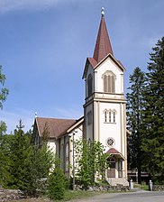 Enonkosken kirkko (1886). Ylä-Enonvedelle osoittava kirkontornin risti toimii muistomerkkinä syksyn 1858 kirkkoveneonnettomuudesta.