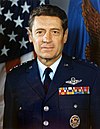 man in Air Force uniform, blue flag in background