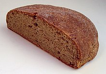 Photo d’un demi-pain dont la teinte est légèrement plus orangée que celle d’un pain gris traditionnel.