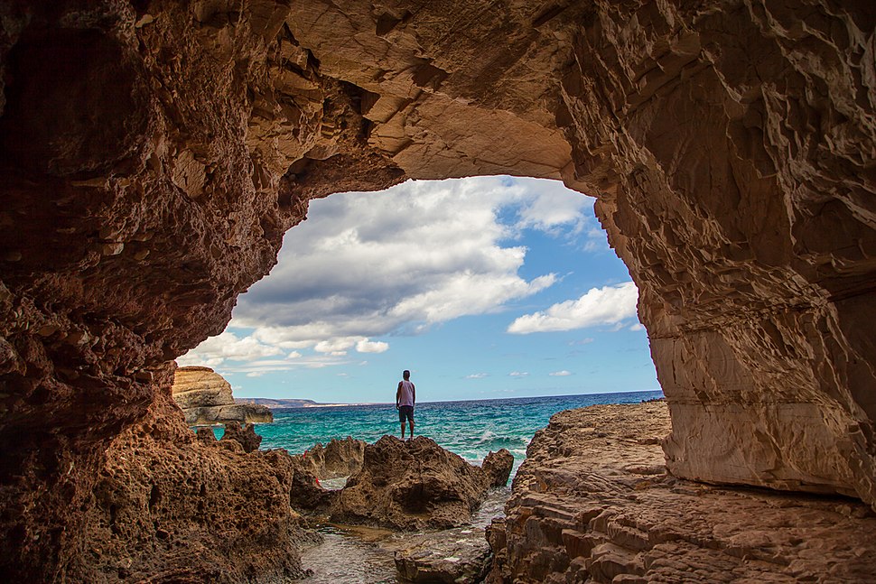 Photographie d’une grotte ouverte sur la mer.