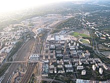 The former classification yard dividing the whole district is clearly visible in a 2010 aerial photograph. The 1990s station building by the bridge was later demolished and replaced by today's Tripla complex.