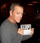 Sutherland holding a check for The 1 Second Film